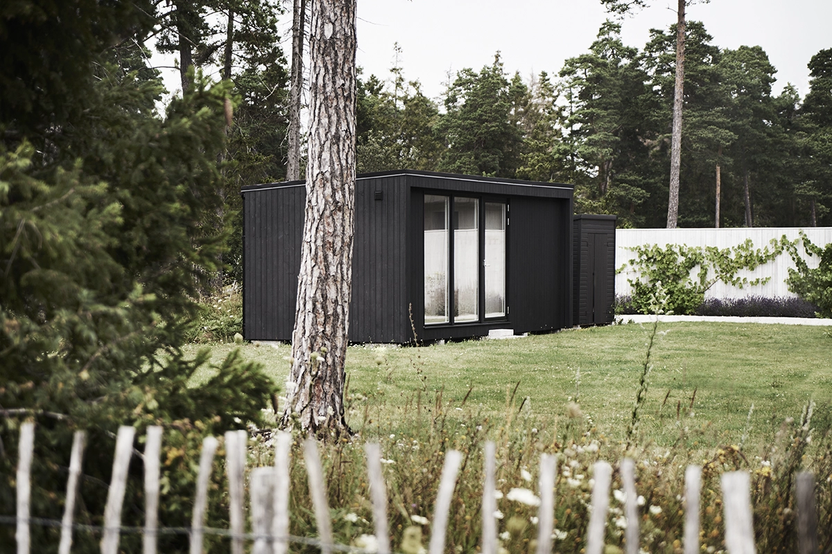 Hytte 25 m2 i en hage. Sort hytte med store vinduer