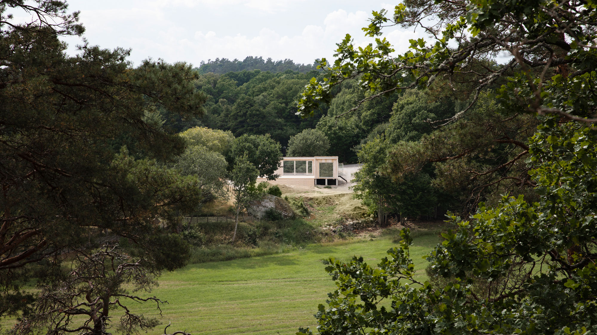 Fritidshus Enkelrum Karlshamn – 68 kvm med träfasad, stora fönster och modern arkitektur, harmoniskt placerat i naturskön miljö.