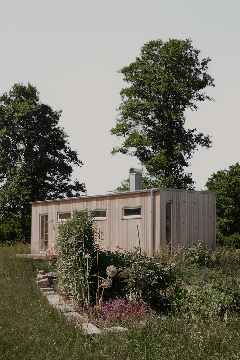 a small wooden building in a grassy area