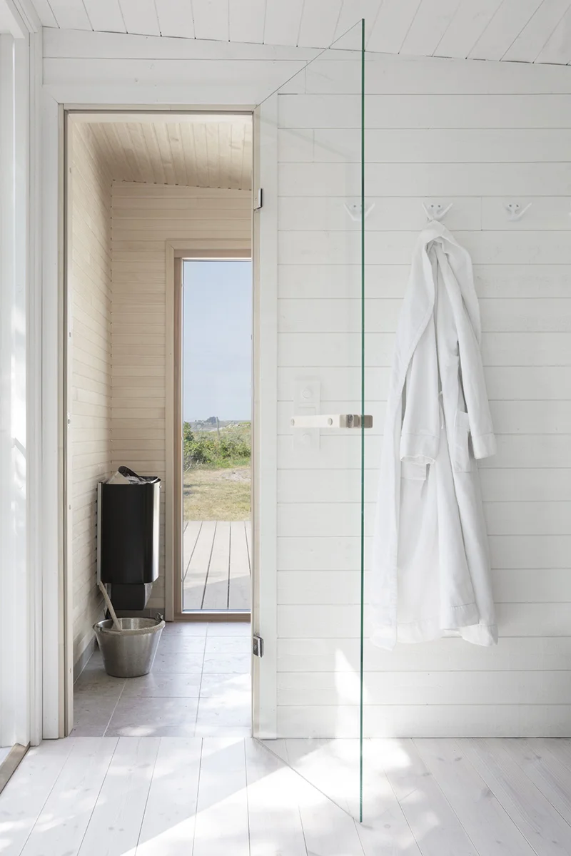 Bastuhus med relax inredning med vitmålade väggar