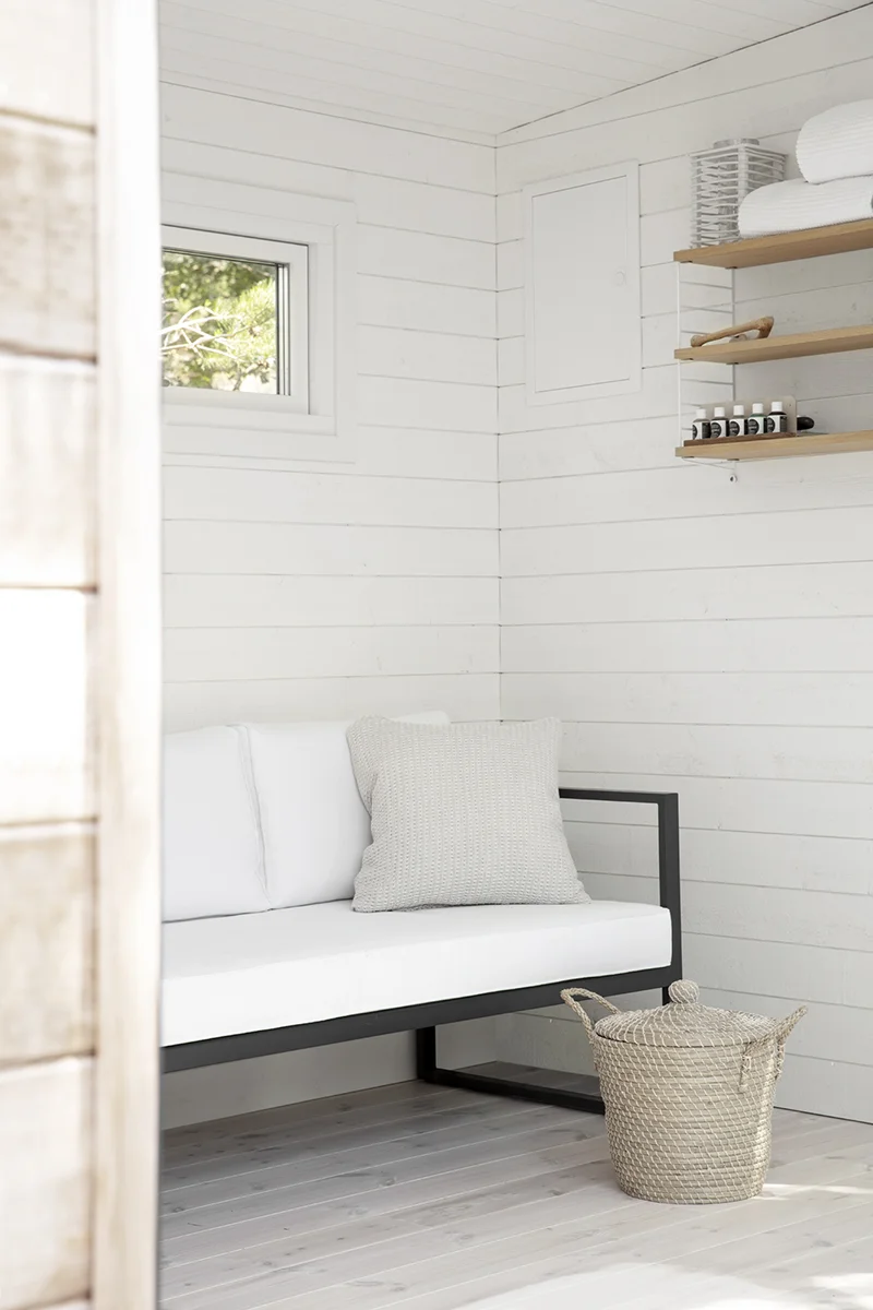 Bastuhus med relax interiör med en soffa och bokhylla