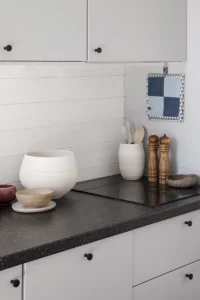 Detaljbild på köksbänk med spisplatta, skålar och kryddor