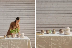 Emma utanför sitt attefallshus ställer upp sina keramikalster på ett bord