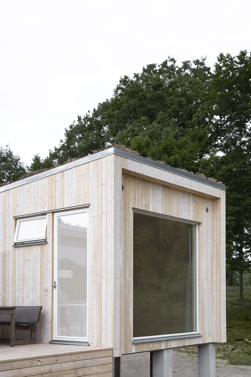 Fritidshus med ljus träpanel och sedumtak