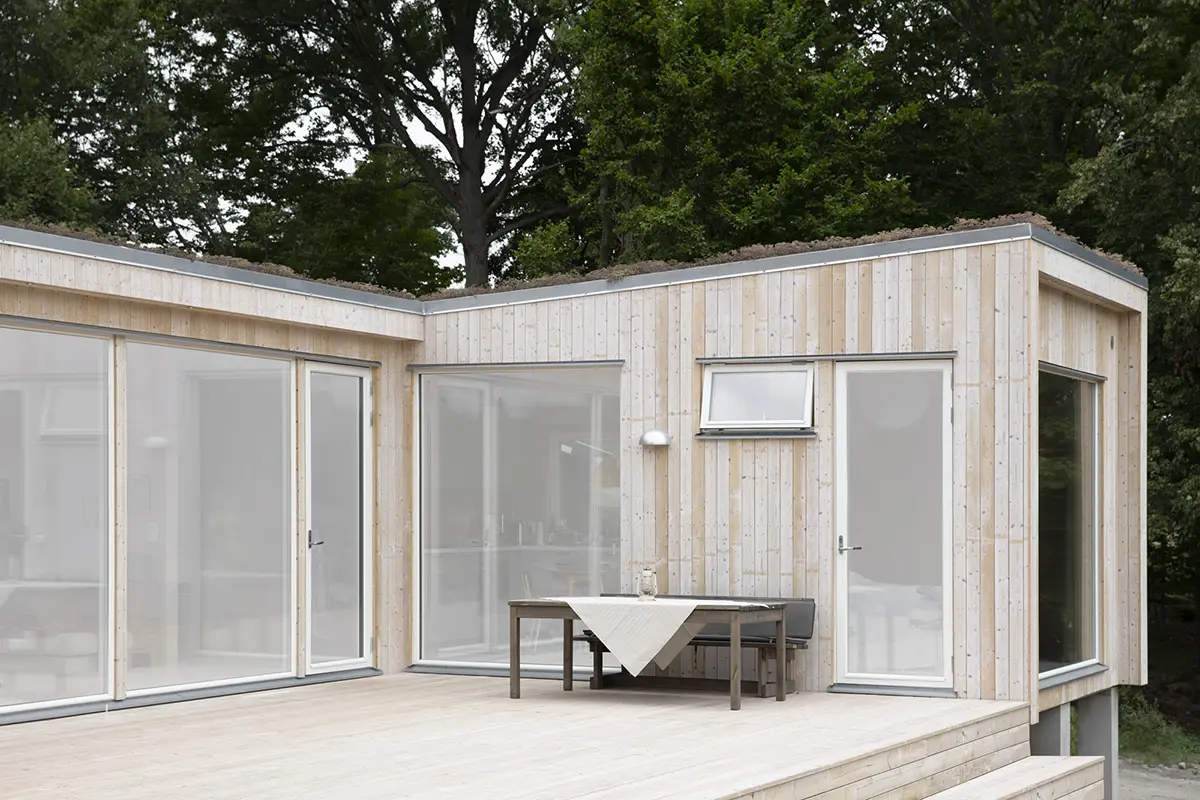 Fritidshus med ljus träpanel och sedumtak