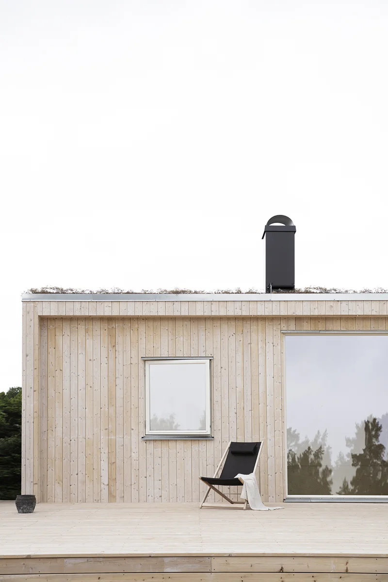 Fritidshus med ljus träpanel och sedumtak