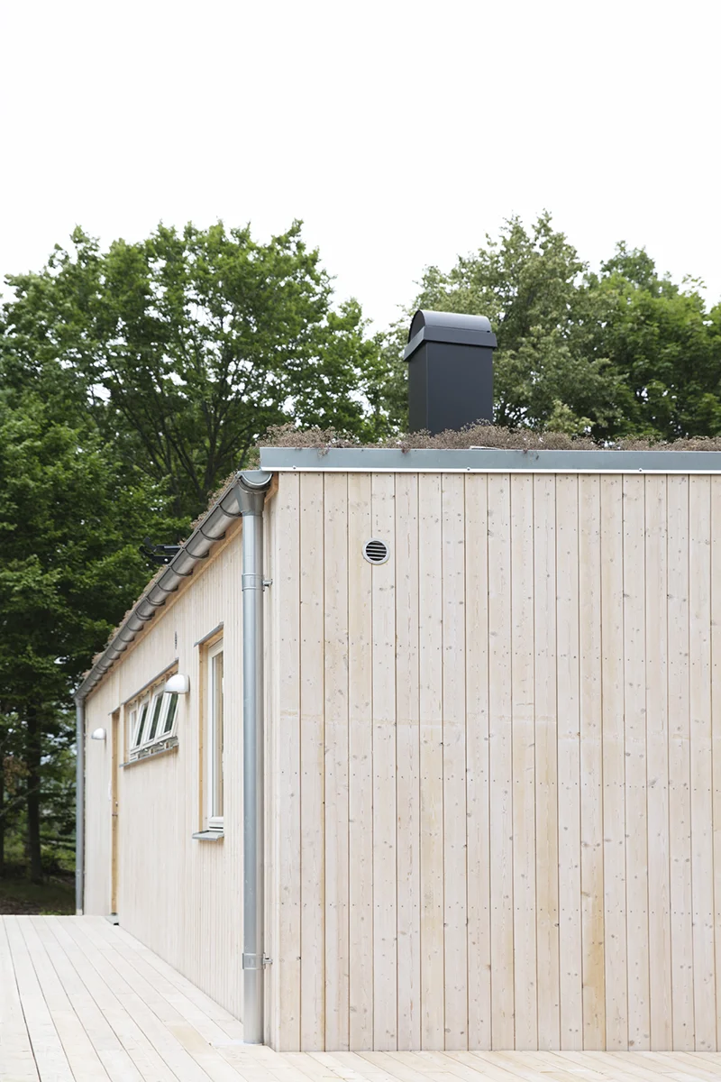 Fritidshus med ljus träpanel och sedumtak