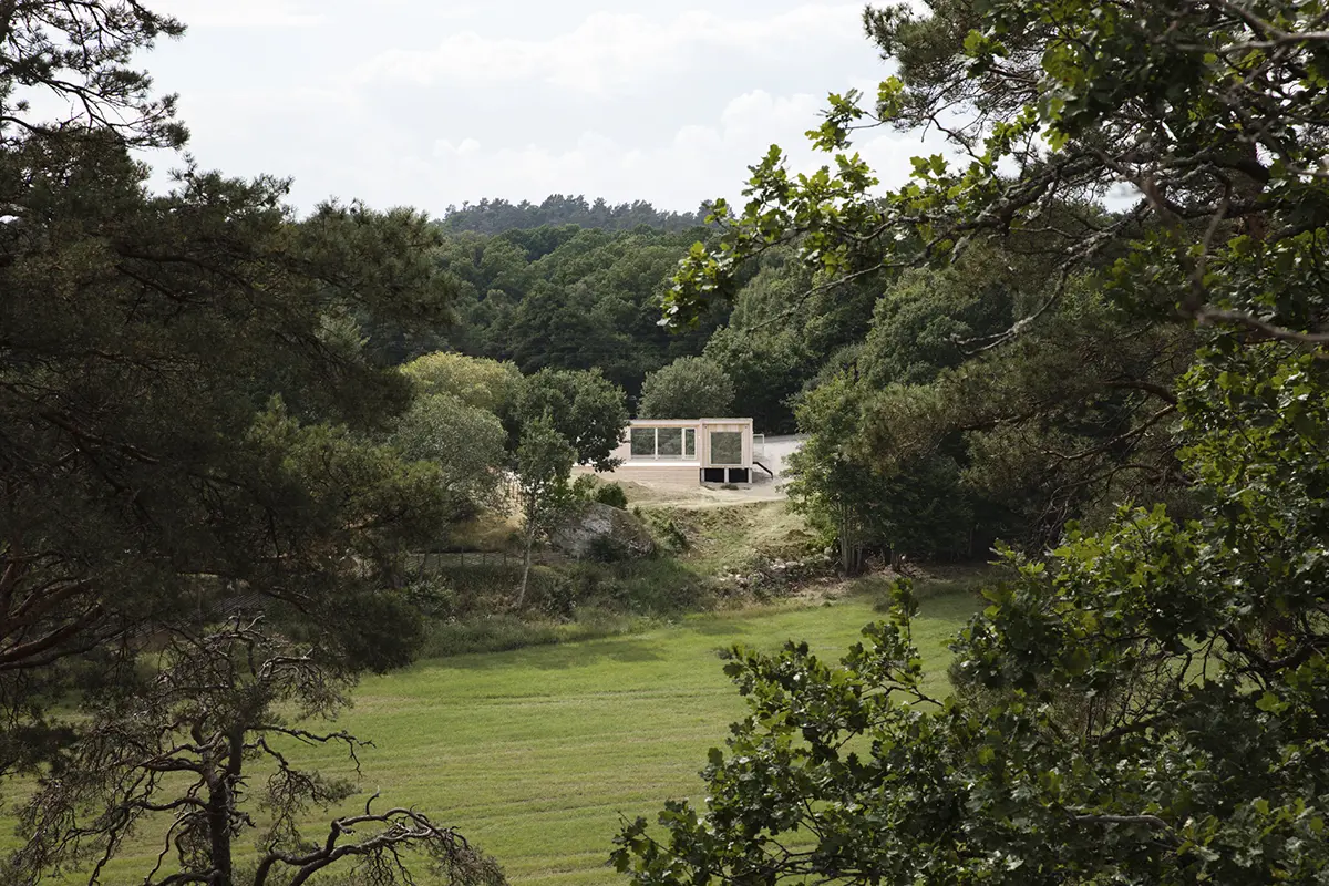 Fritidshus 68 kvm med träfasad, stora fönster och modern arkitektur, placerat i naturskön miljö.
