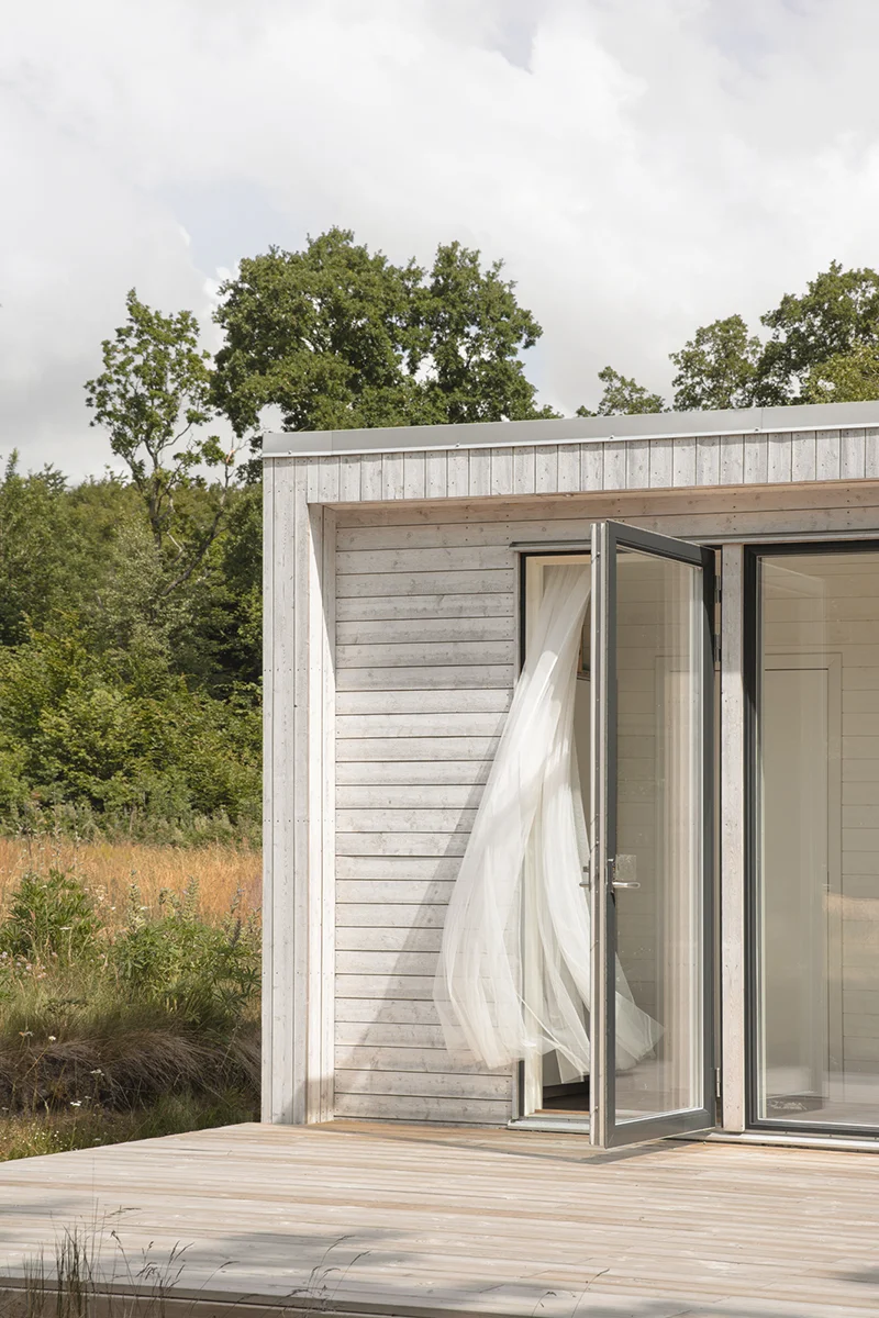 House 30 sqm, exterior detail of a curtain blowing through a door