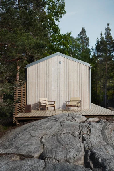 Mikrohus i trä med altan på en klippa