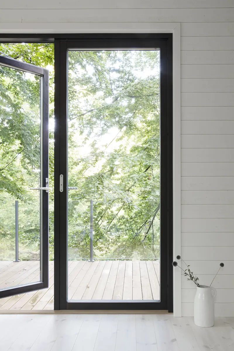 Window door opening out to a terrace in front of green trees